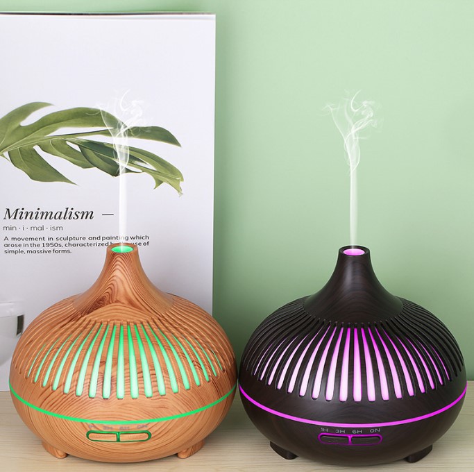 Two diffusers, one wooden and one black with purple lights, on a light green background.