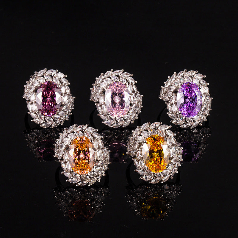 Five gemstone earrings with different colored gemstones on a black background