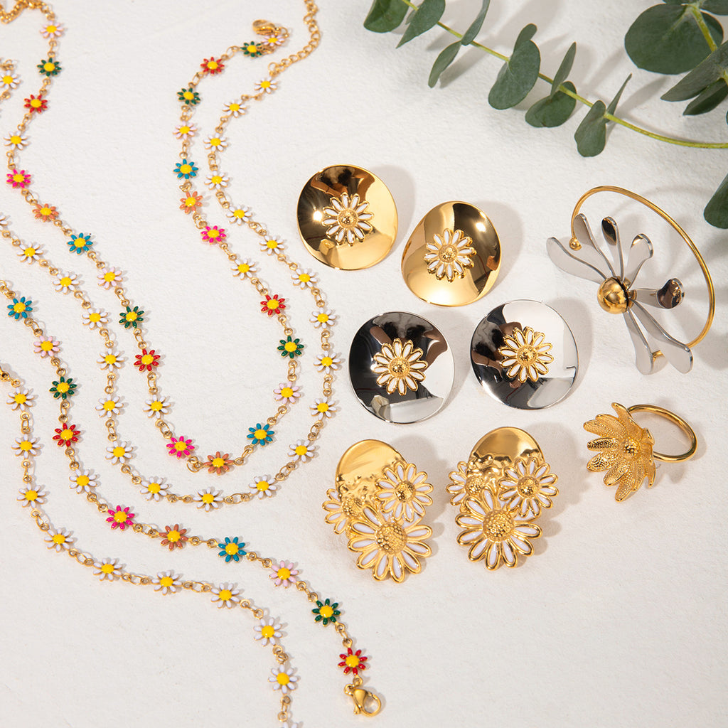 Gold and silver jewelry set with floral designs on a white background