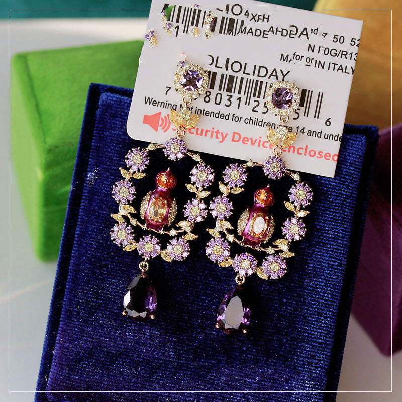 Decorative earrings on a blue card with a barcode label in the background