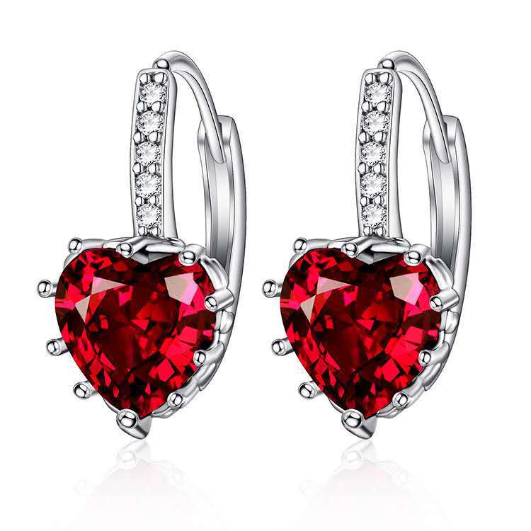 Heart-shaped red gemstone earrings with silver accents on a white background