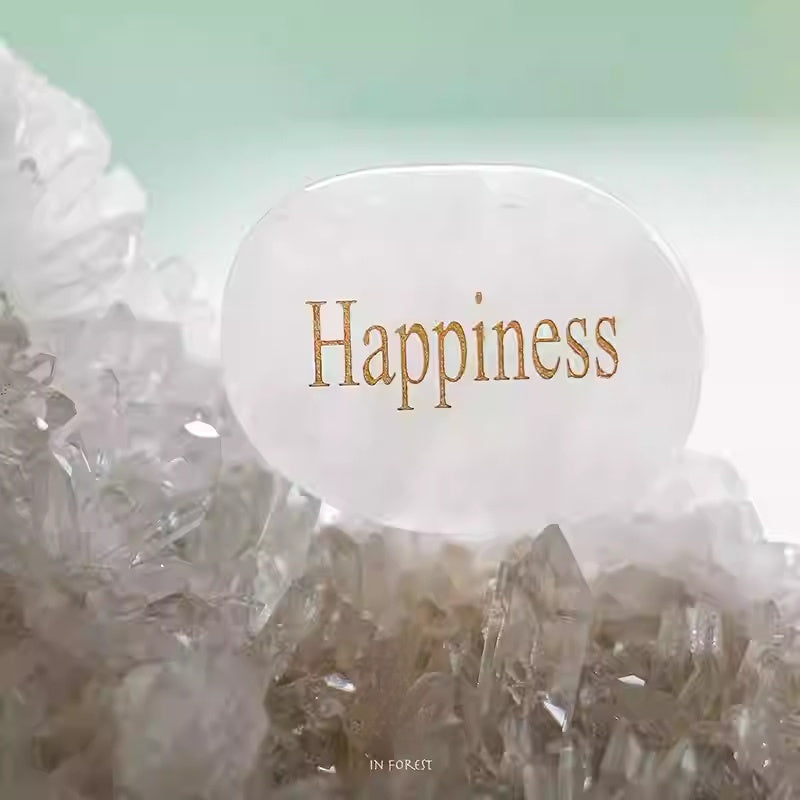 White stone with 'Happiness' text on a crystal background