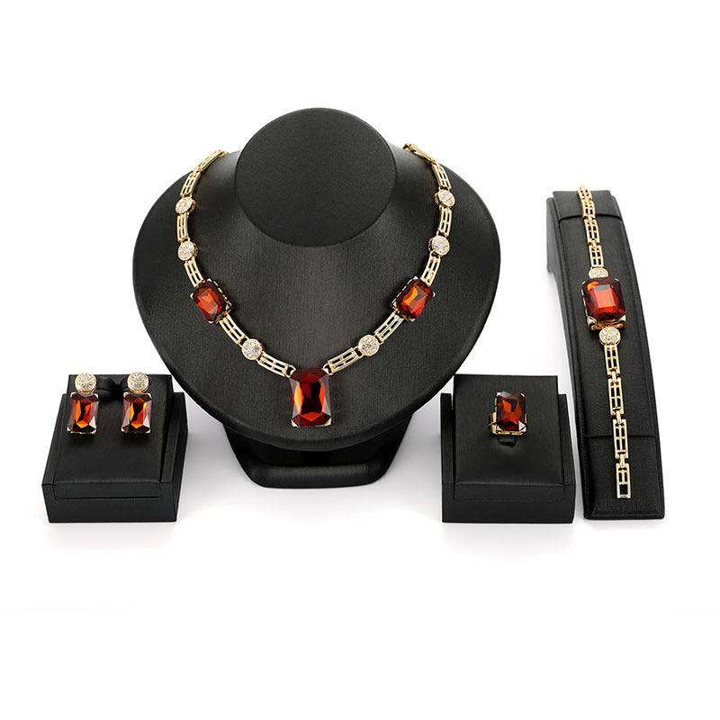 Jewelry set with necklace, bracelet, and earrings on a black stand against a white background