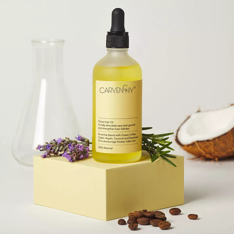 Bottle of Carvenchy hair oil with lavender, rosemary, and coconut on a light background