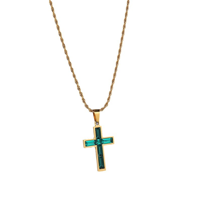 Gold necklace with a green cross pendant on a white background