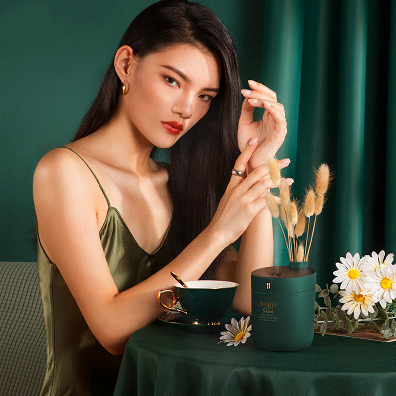 Woman holding a small plant pot with a green background