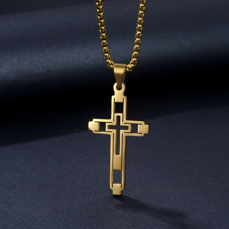 Gold cross pendant on a dark blue fabric background