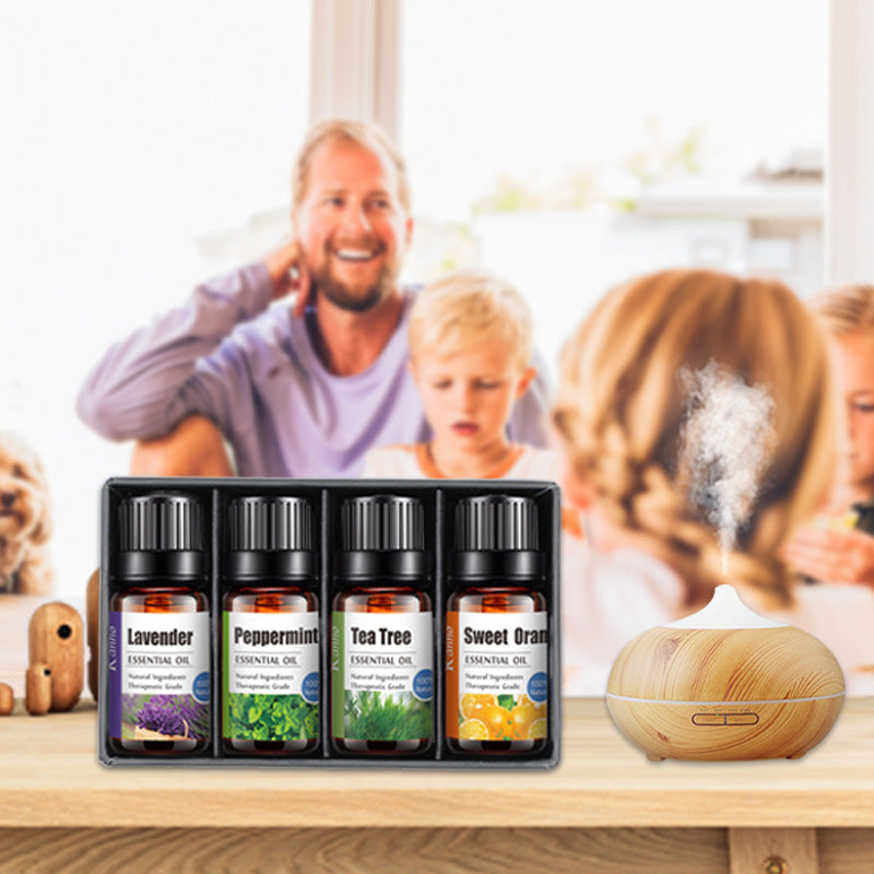 Set of essential oil bottles with a diffuser on a table in front of a family photo.