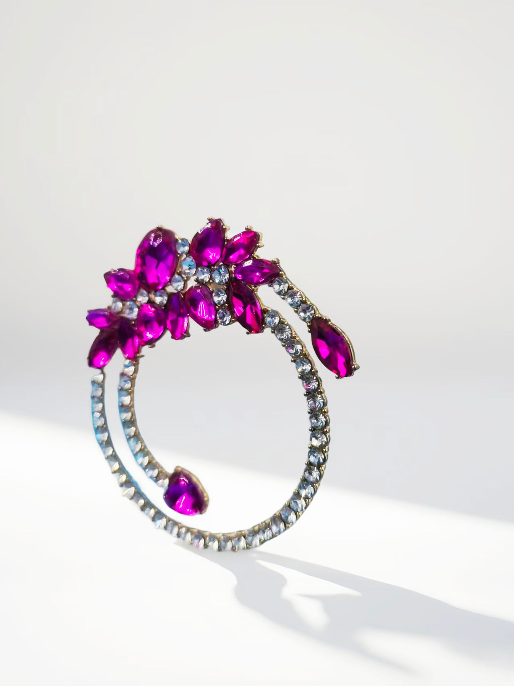 Decorative brooch with pink gemstones on a white background