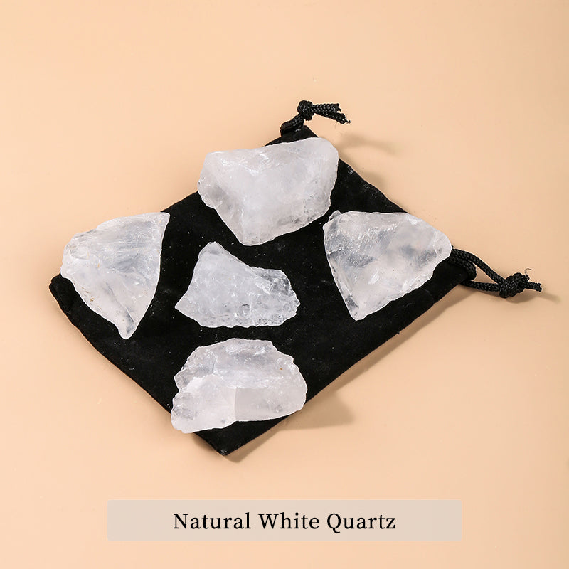 Black drawstring bag with natural white quartz stones on a beige background