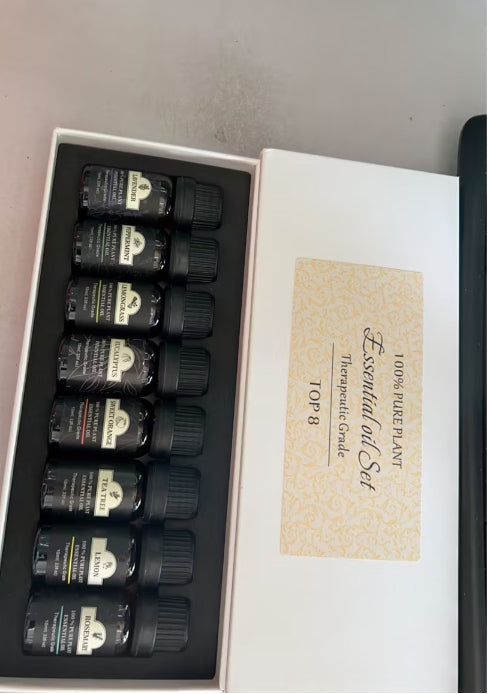 Set of essential oil bottles in a box with a label on a gray surface