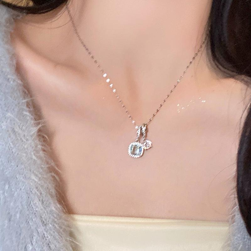 Necklace with a pendant worn by a person, with a soft focus on the background