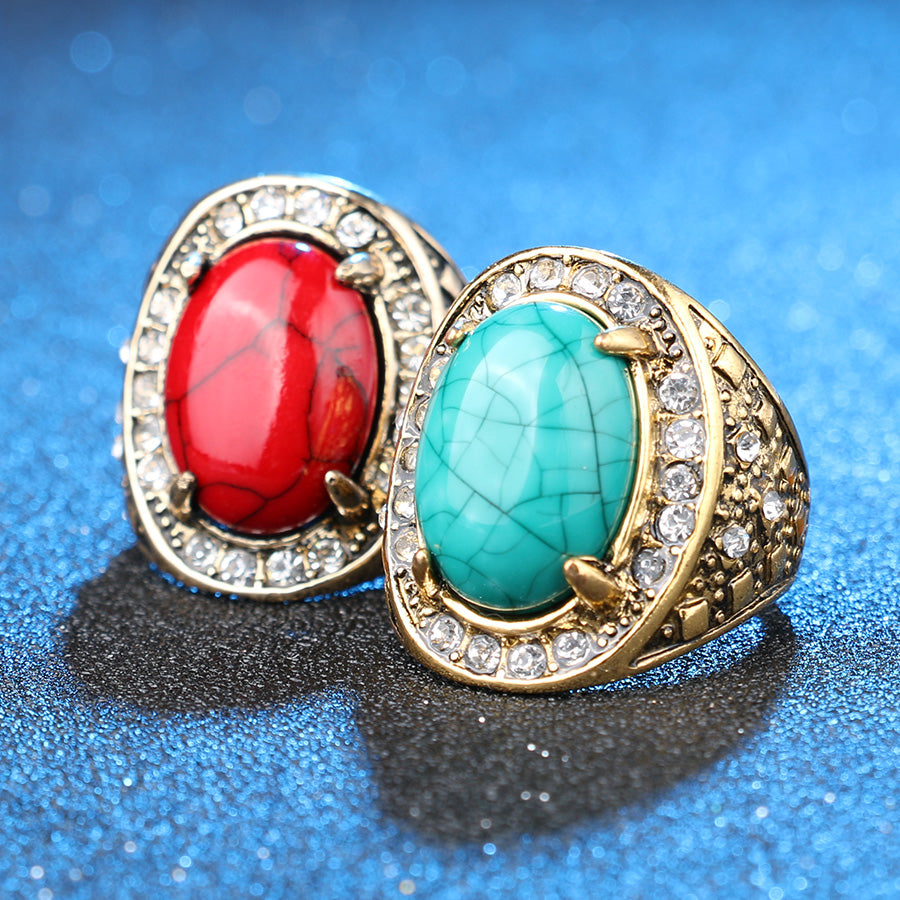 Two rings with red and turquoise stones on a blue background