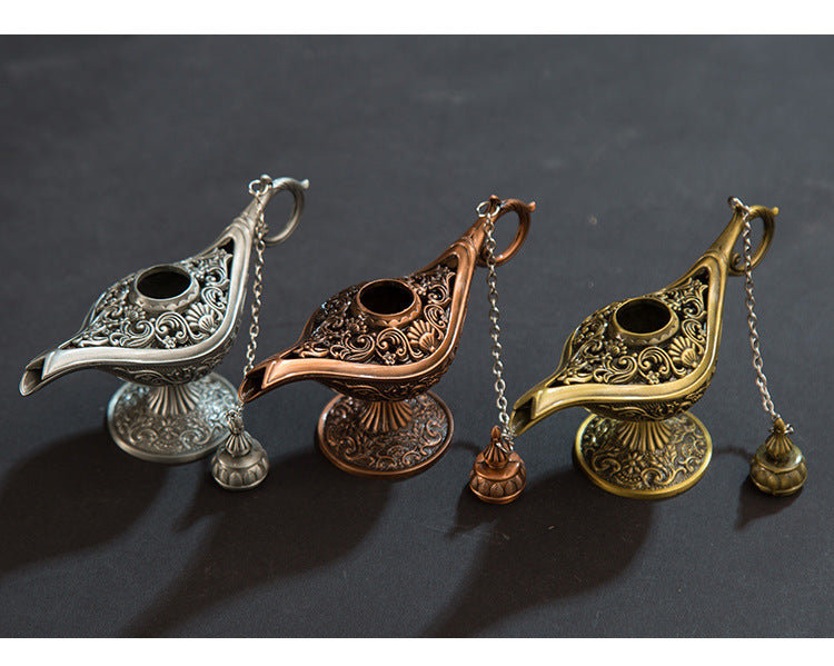 Three ornate lamps in silver, bronze, and gold on a dark background