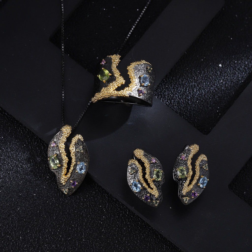 Gold and gemstone jewelry set on a black background