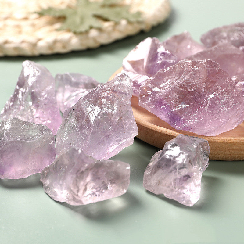 Pink crystal rocks on a wooden tray with a light green background