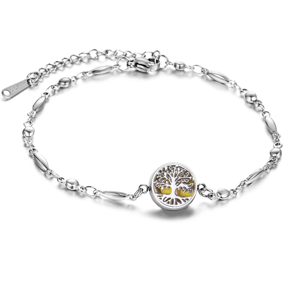 Silver bracelet with a tree of life charm on a white background