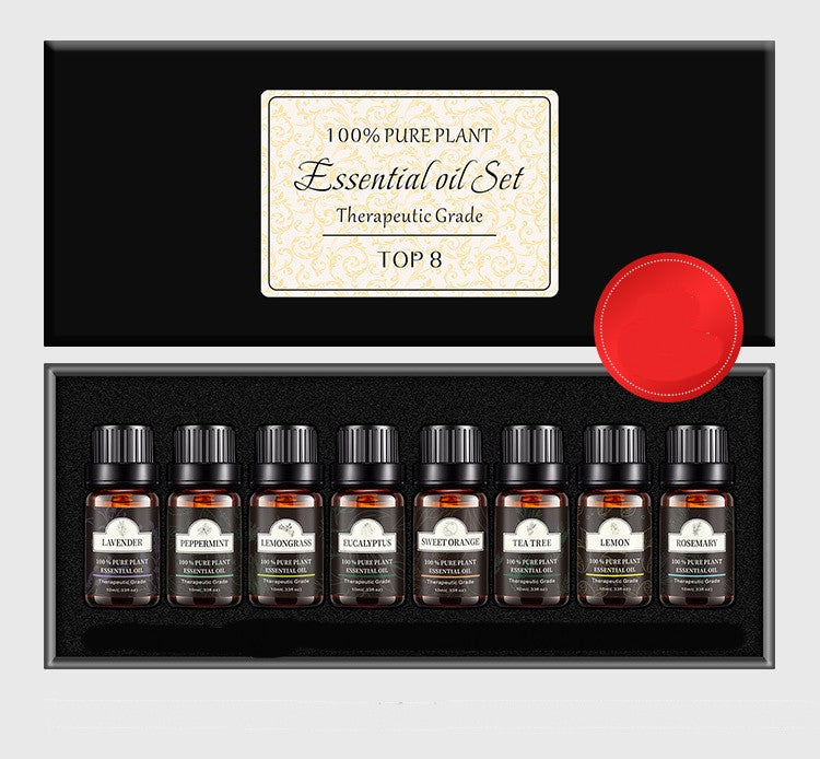 Set of essential oil bottles in a black box with a red circular label on a light gray background