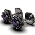 Pair of silver earrings with purple gemstones on a white background