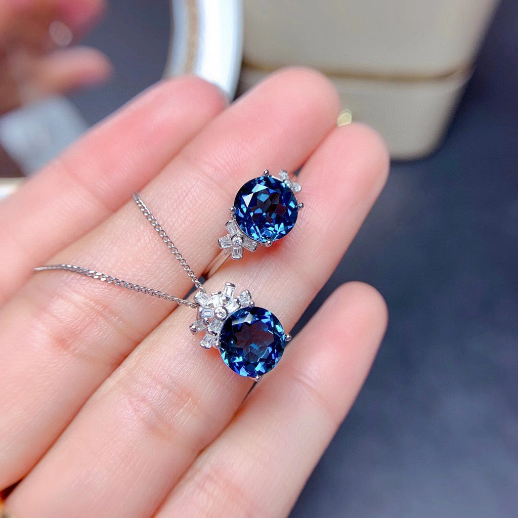 Blue gemstone pendants on a hand with a blurred background