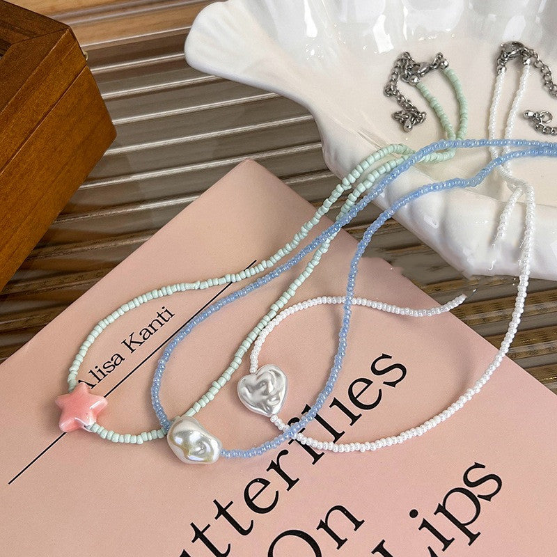 Three beaded necklaces with decorative elements on a book
