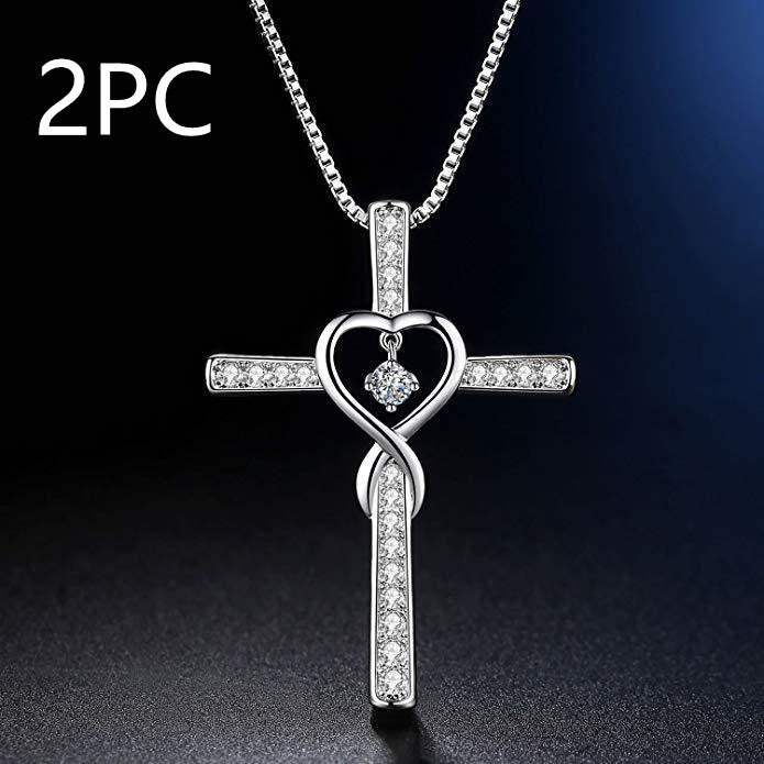 Silver cross pendant with heart design on a dark background