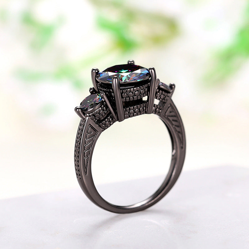 Black diamond ring with intricate design on a white background