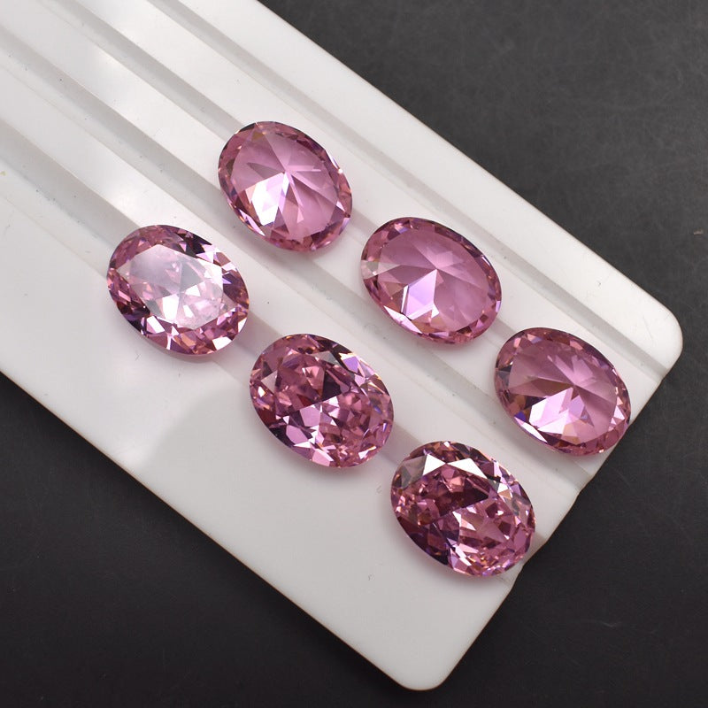 Pink gemstones on a white tray against a dark background
