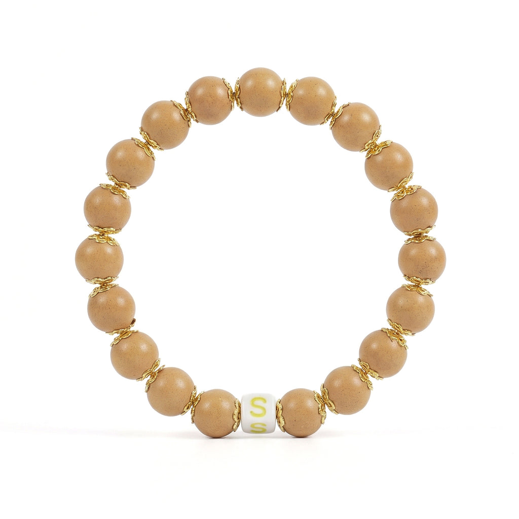 Beige beaded bracelet with gold accents on a white background