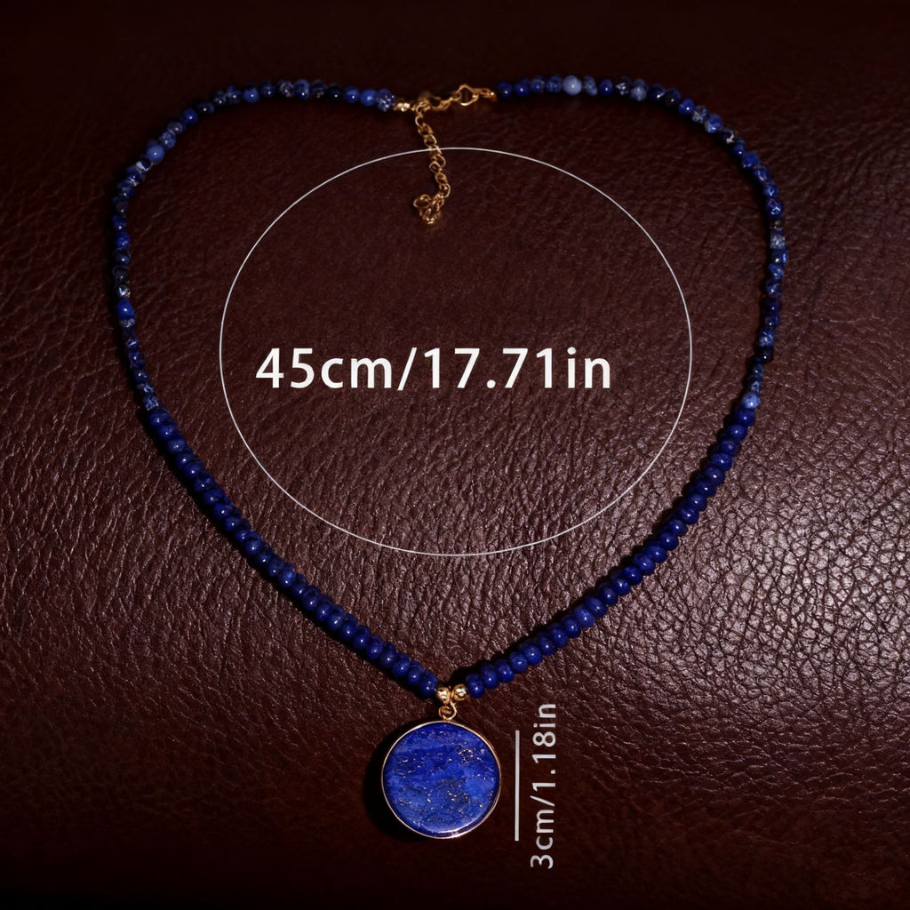 Blue beaded necklace with a pendant on a brown textured background