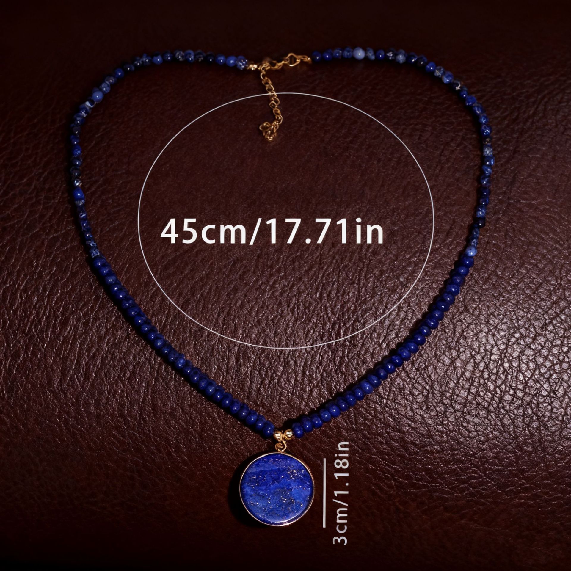Blue beaded necklace with a pendant on a brown textured background