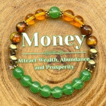 Beaded bracelet with green, orange, and brown beads on a wooden surface, featuring text about attracting wealth.