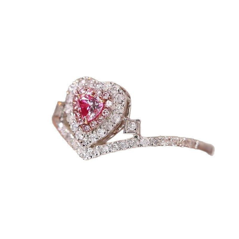 Ring with a heart-shaped pink gemstone and diamond-studded band on a white background