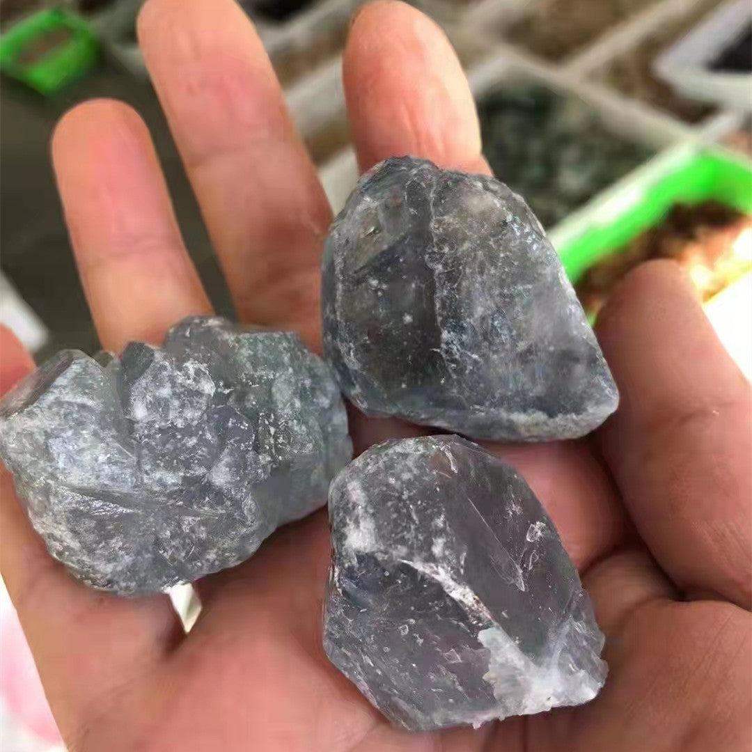 Three rough diamonds held in a hand with a blurred background