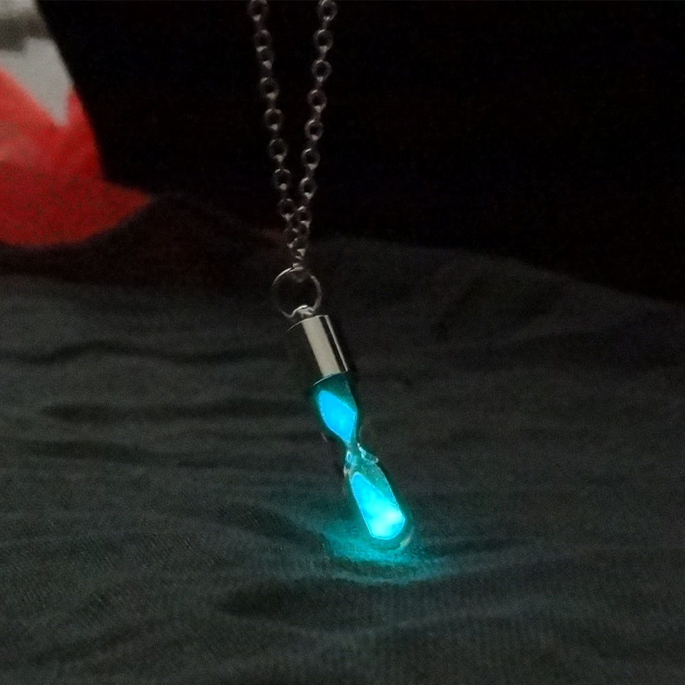 Glowing blue pendant on a chain against a dark background
