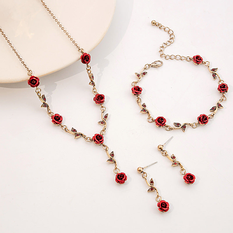 Jewelry set with red rose designs on a white background