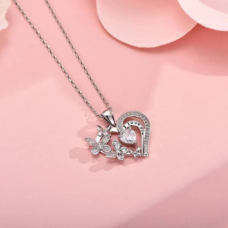 Heart-shaped pendant with butterfly design on a pink background