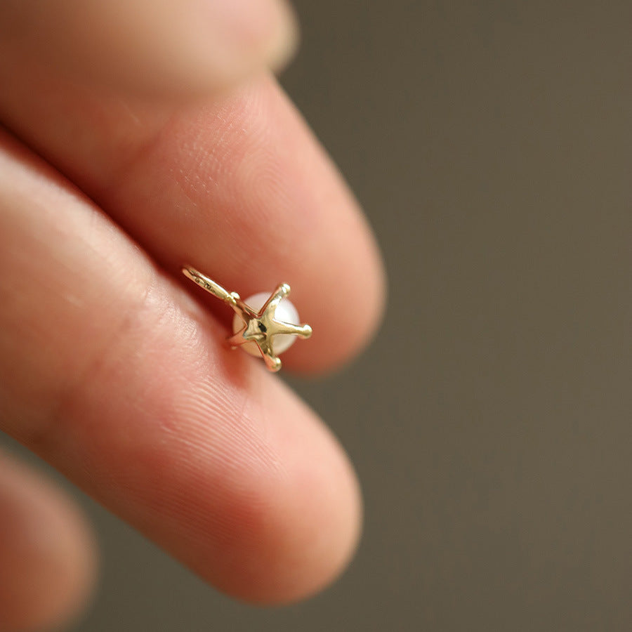 Gold ring with a pearl on a finger against a blurred background