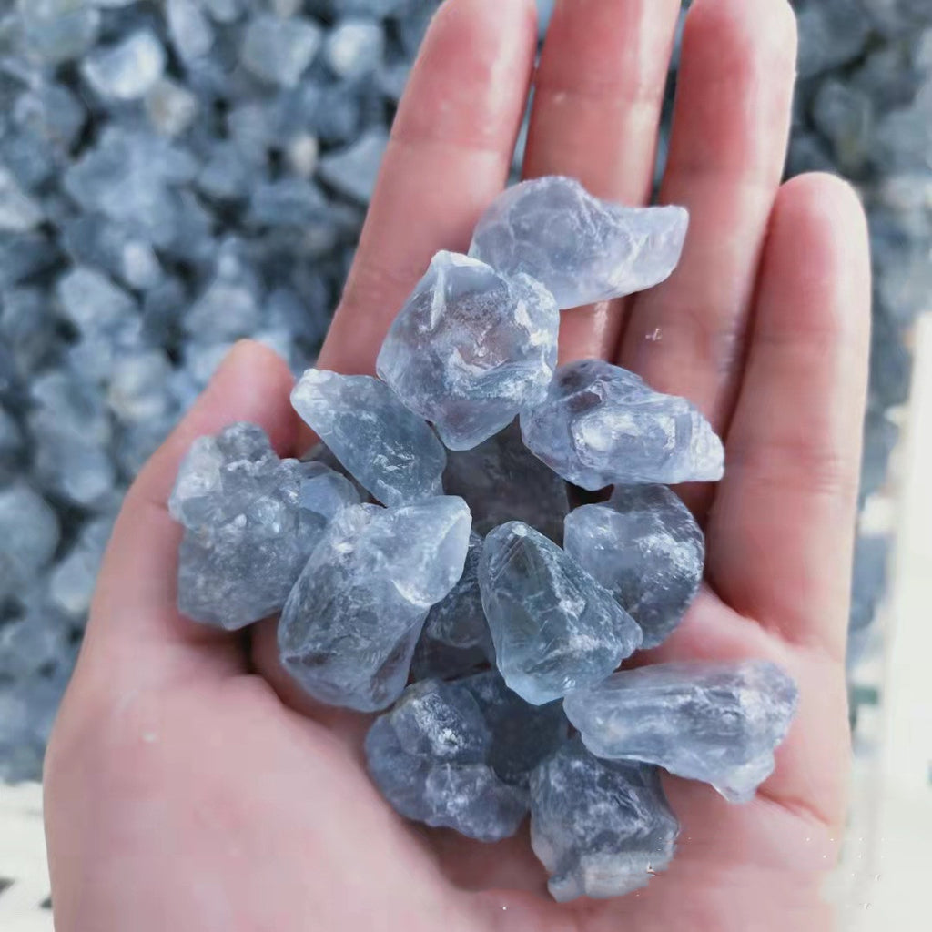 Hand holding a collection of clear crystals against a blurred natural background