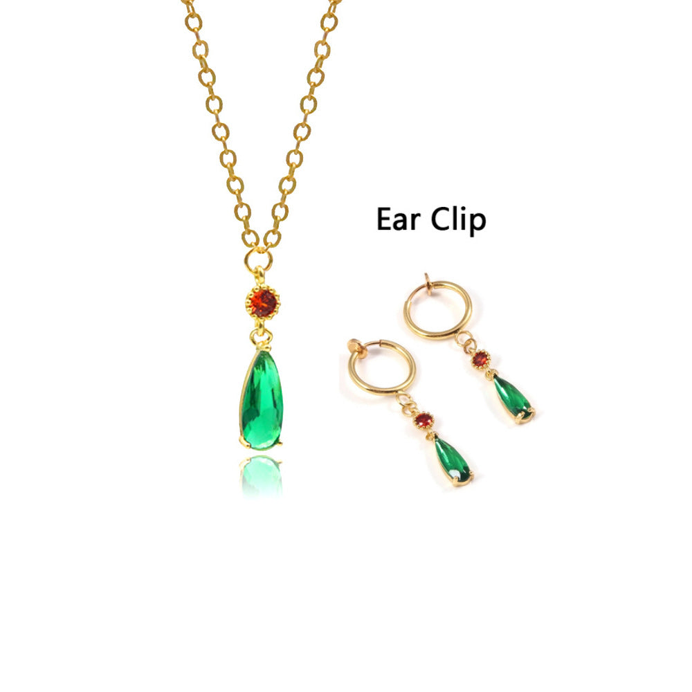 Gold necklace with green teardrop pendants on a white background