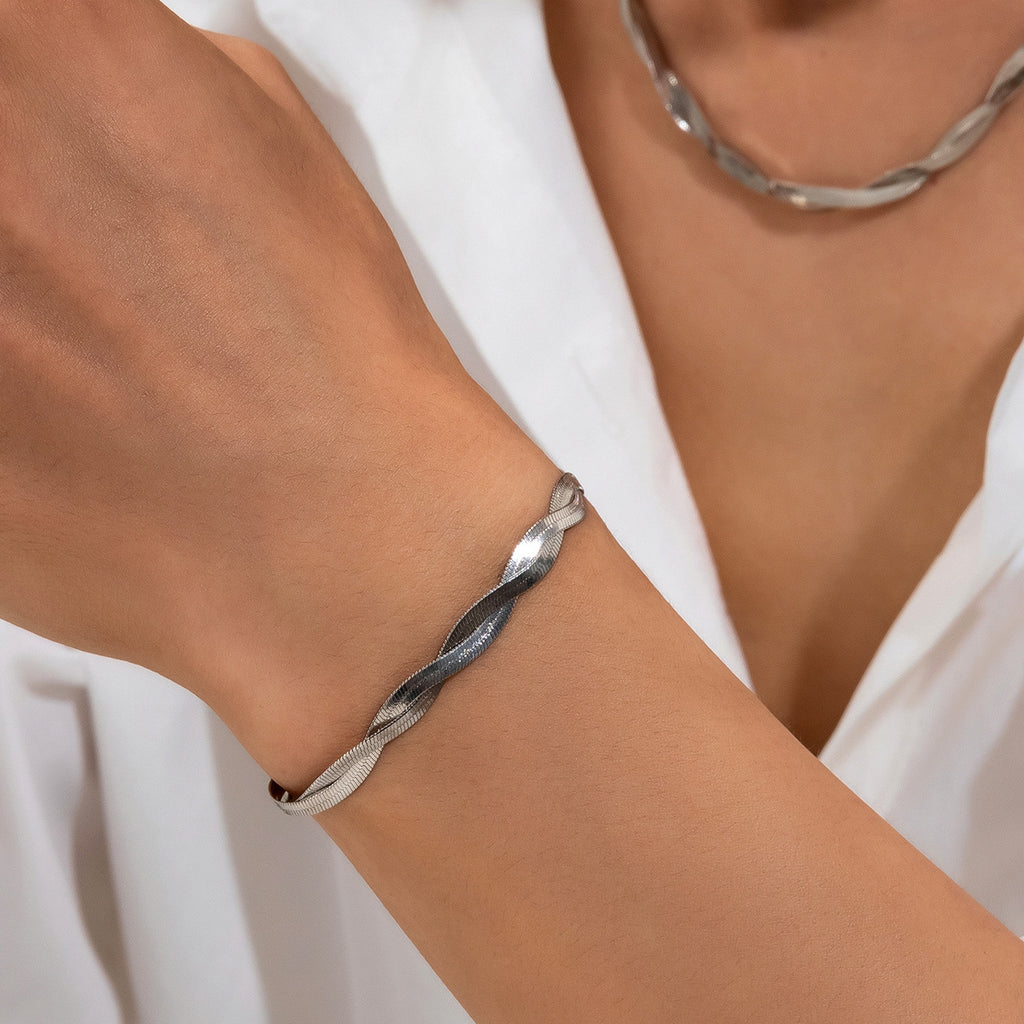 Silver bracelet on a wrist with a white background