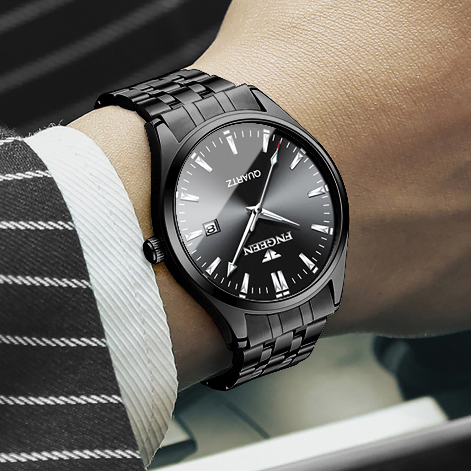 Black wristwatch on a person's arm with a blurred background