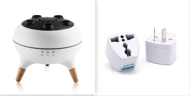 White and black device with wooden legs on a white background, next to two white plugs.