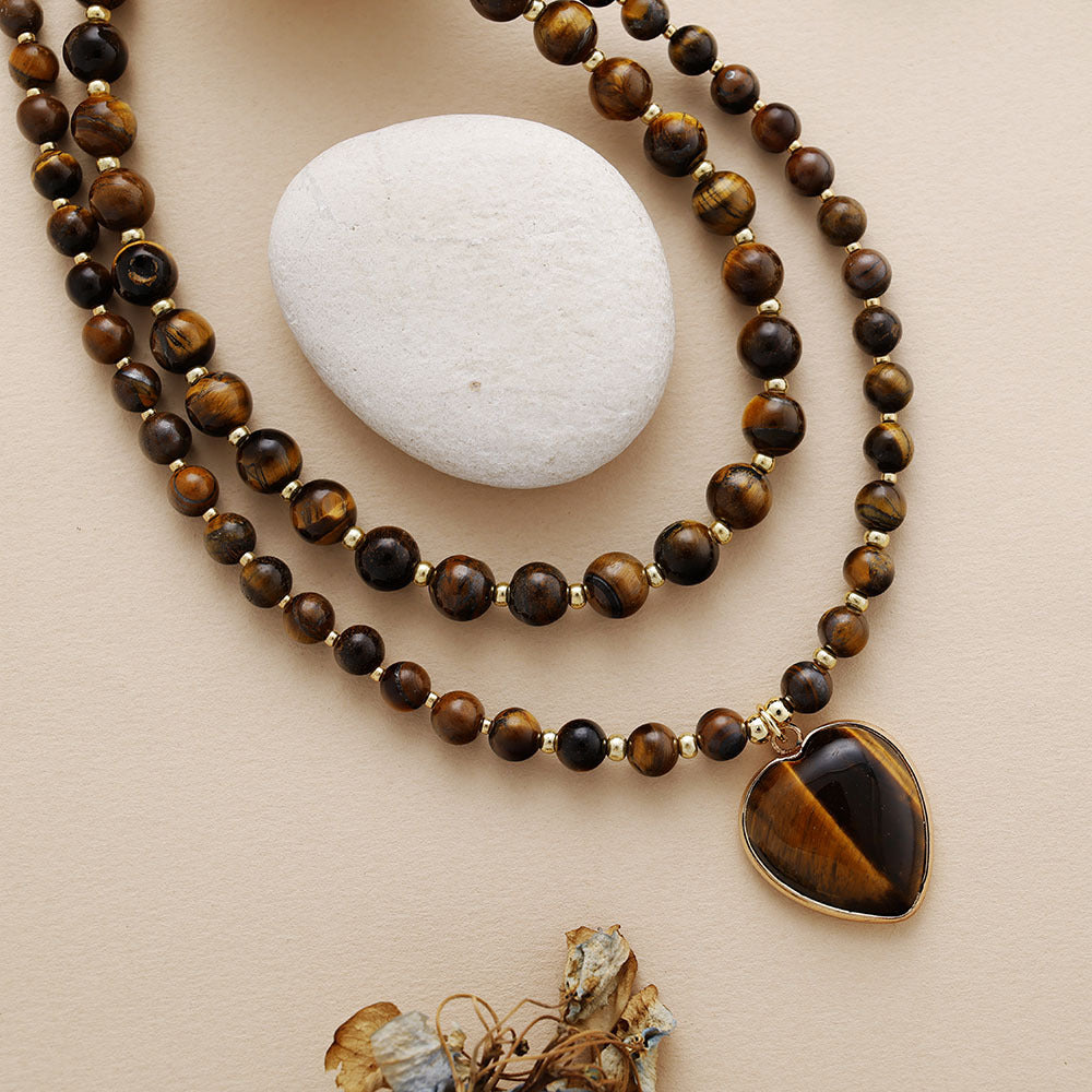 Beaded necklace with a heart-shaped pendant on a beige surface