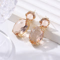 Pair of earrings with pink gemstones on a white surface