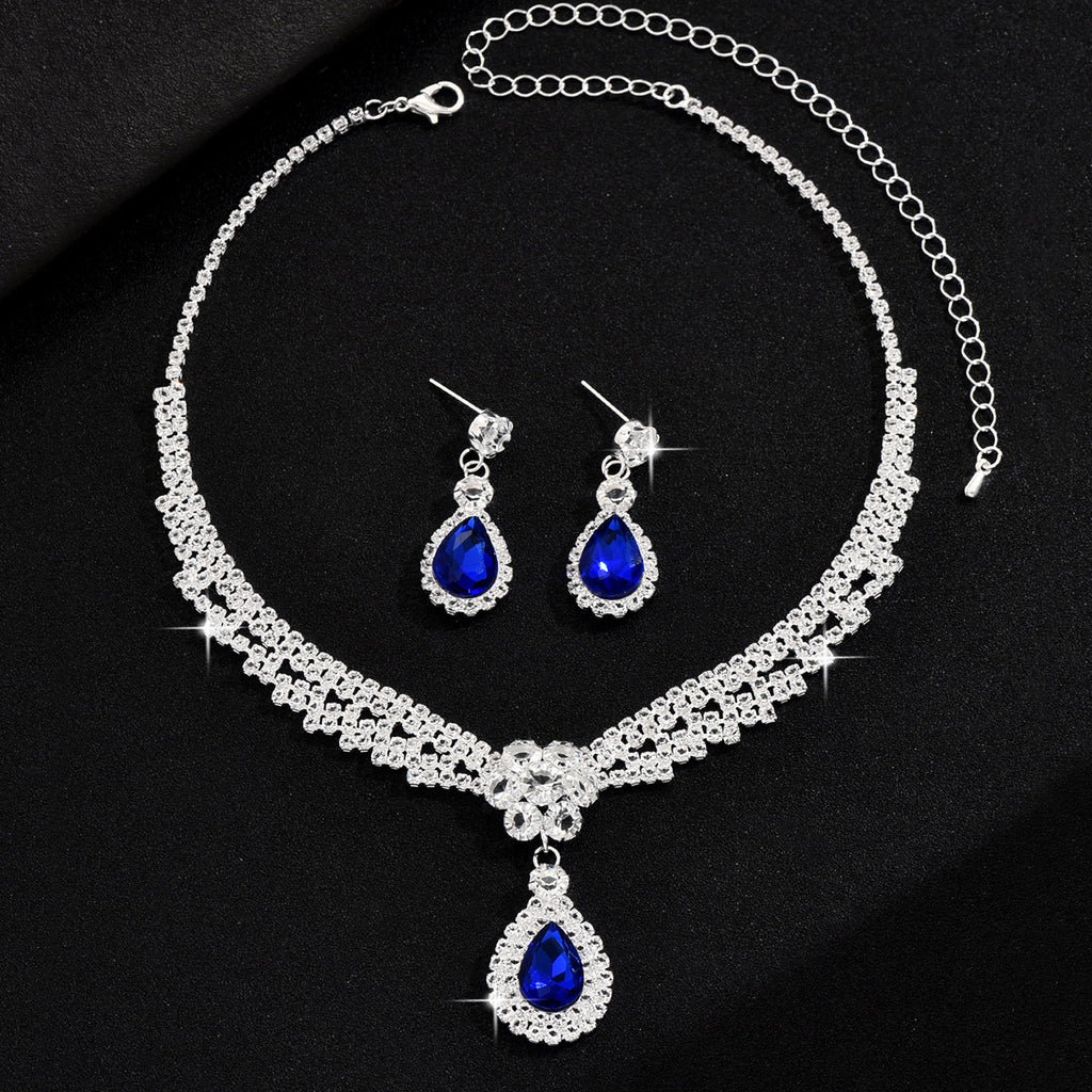 Jewelry set with necklace and earrings featuring blue teardrop stones on a black background