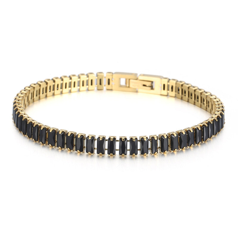 Gold bracelet with black stones on a white background