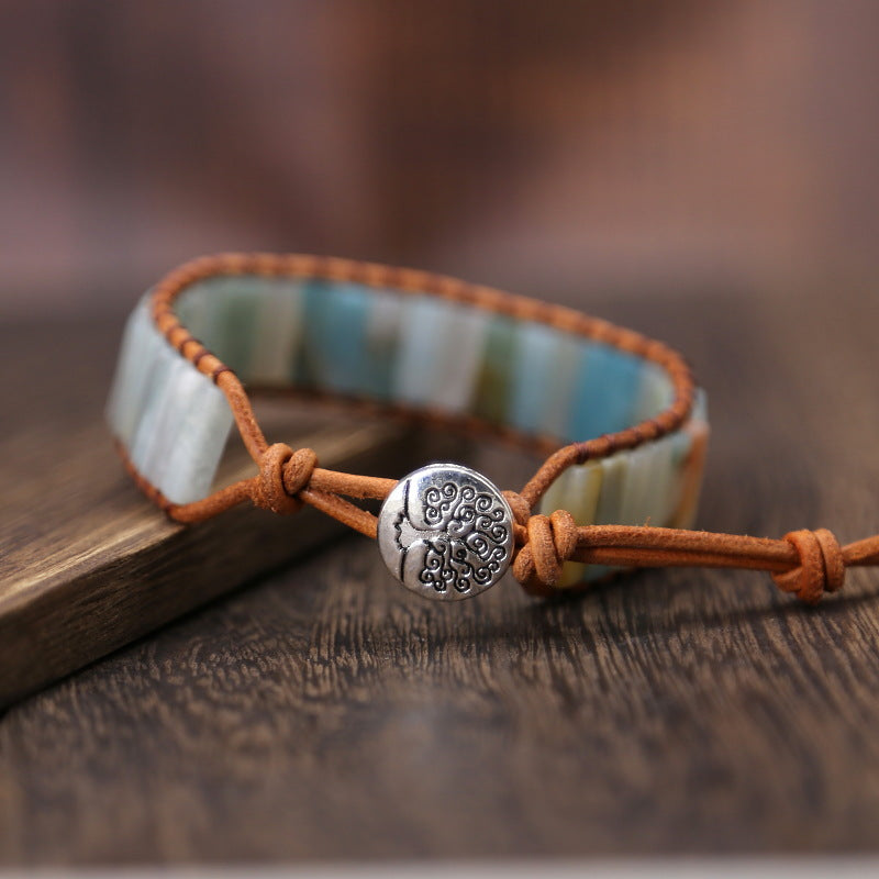 Bracelet with a tree of life charm on a wooden surface