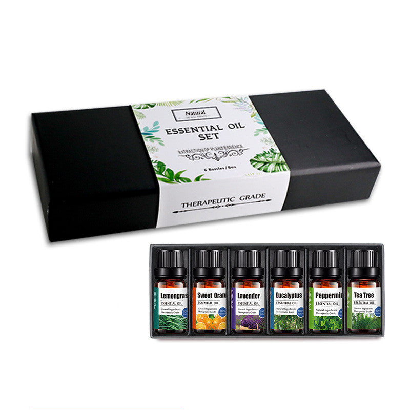 Essential oil set with black box labeled 'Natura' and eight bottles on a white background