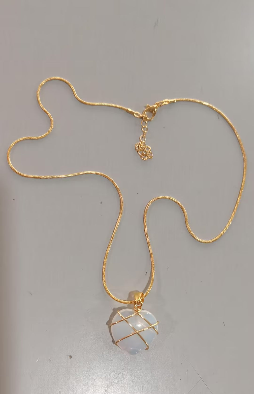 Gold necklace with a pendant on a gray background